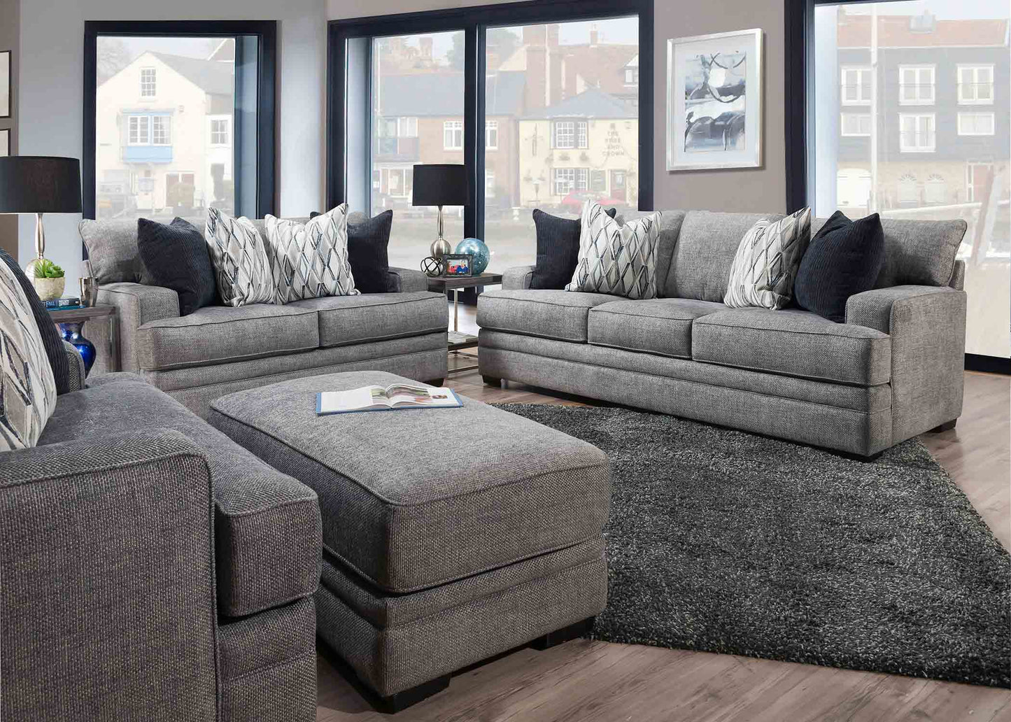 Gray sectional sofa with patterned cushions in a living room setting.