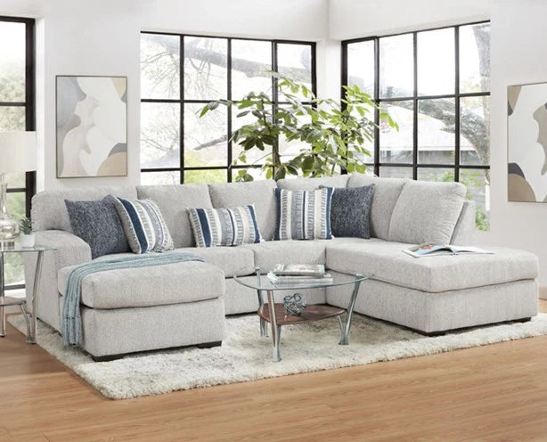 Gray sectional sofa with blue patterned pillows in a living room setting.