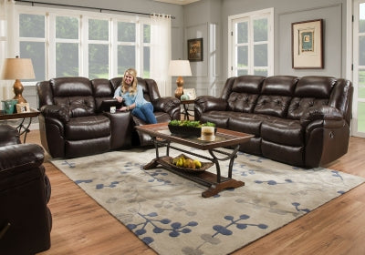 Living room with dark brown leather sofa set and a woman sitting on a chair.