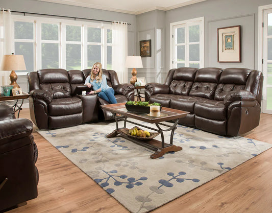 Living room with brown leather recliner sofa set and a woman sitting on one of the chairs.