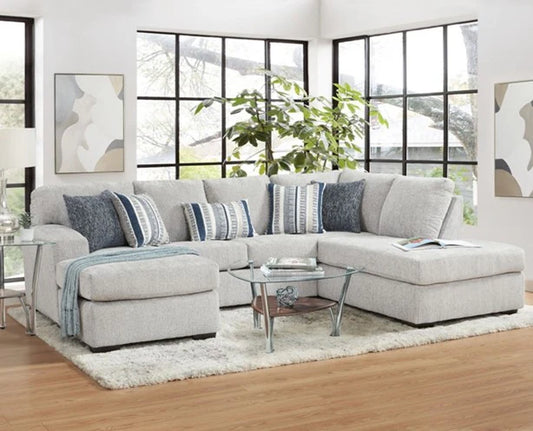 Gray sectional sofa with blue patterned pillows in a living room setting.