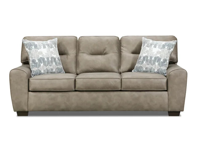 Beige sofa with two patterned pillows on a white background