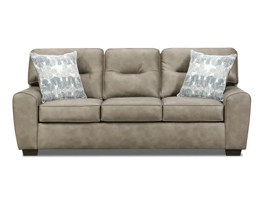 Beige sofa with two patterned pillows on a white background