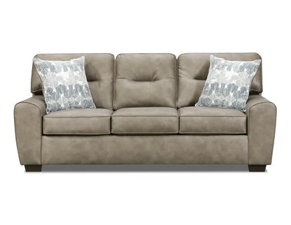 Beige sofa with two patterned pillows on a white background