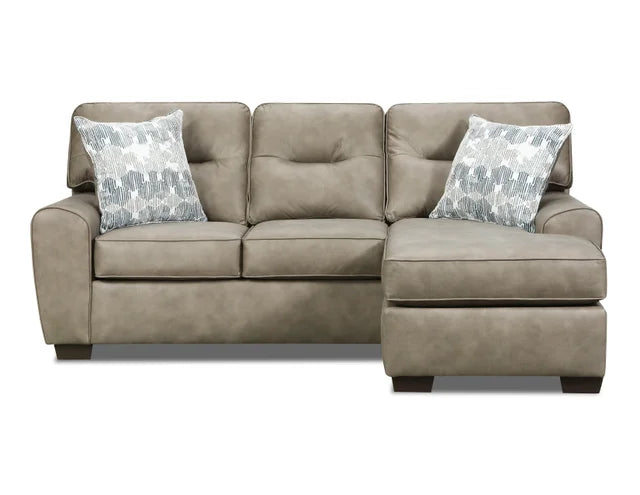 Beige sectional sofa with patterned pillows on a white background