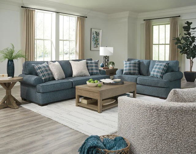 Living room with blue sectional sofa, wooden coffee table, and decorative elements.