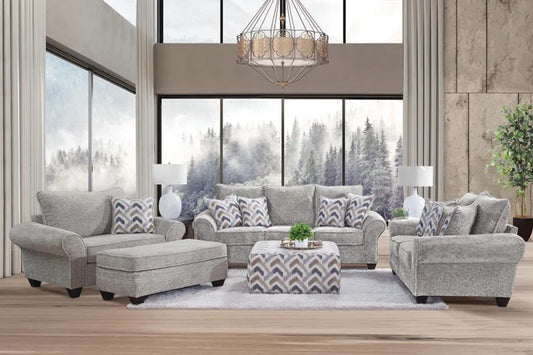Gray sofa set in a modern living room with large windows.